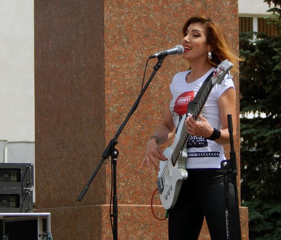 Một người phụ nữ đang hát với cây đàn guitar